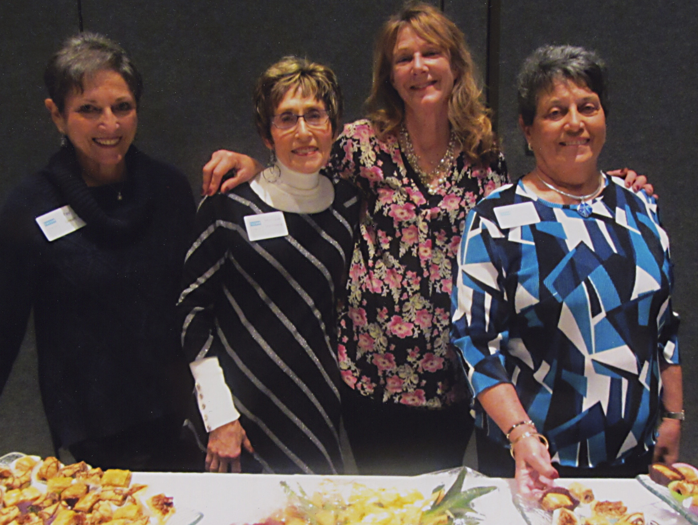 Tucson International Jewish Film Festival committee members Fay Green, Monique Steinberg and Deanna Mendelow with caterer Gwen Amar (second from right) arrange the Israeli buffet. (Sharon Klein)