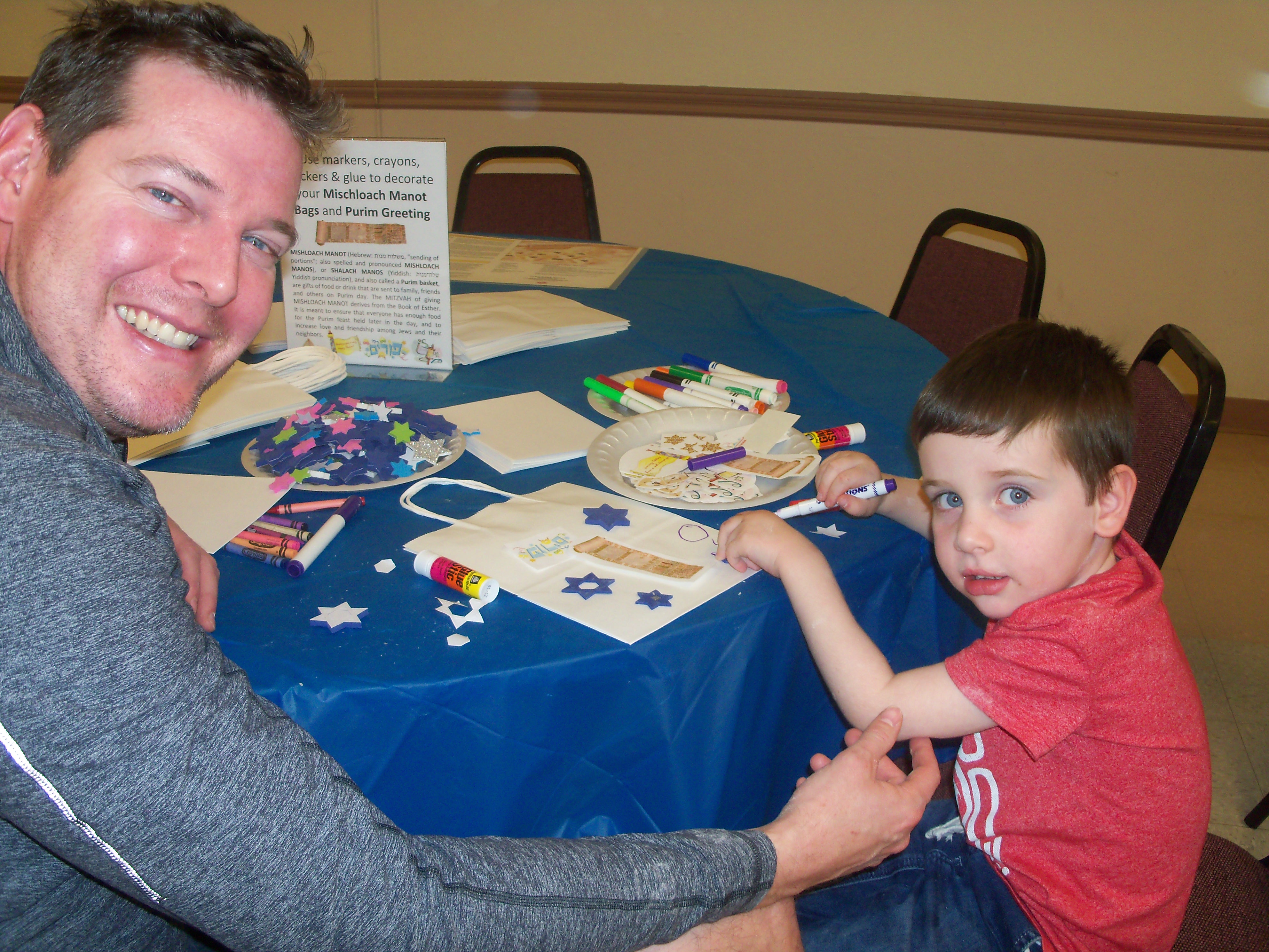 Ken Morris and his son, Asher, decorate gift bags for Purim at CAI's Hamentaschen for Hunger event Feb. 26. (Korene Charnofsky Cohen)