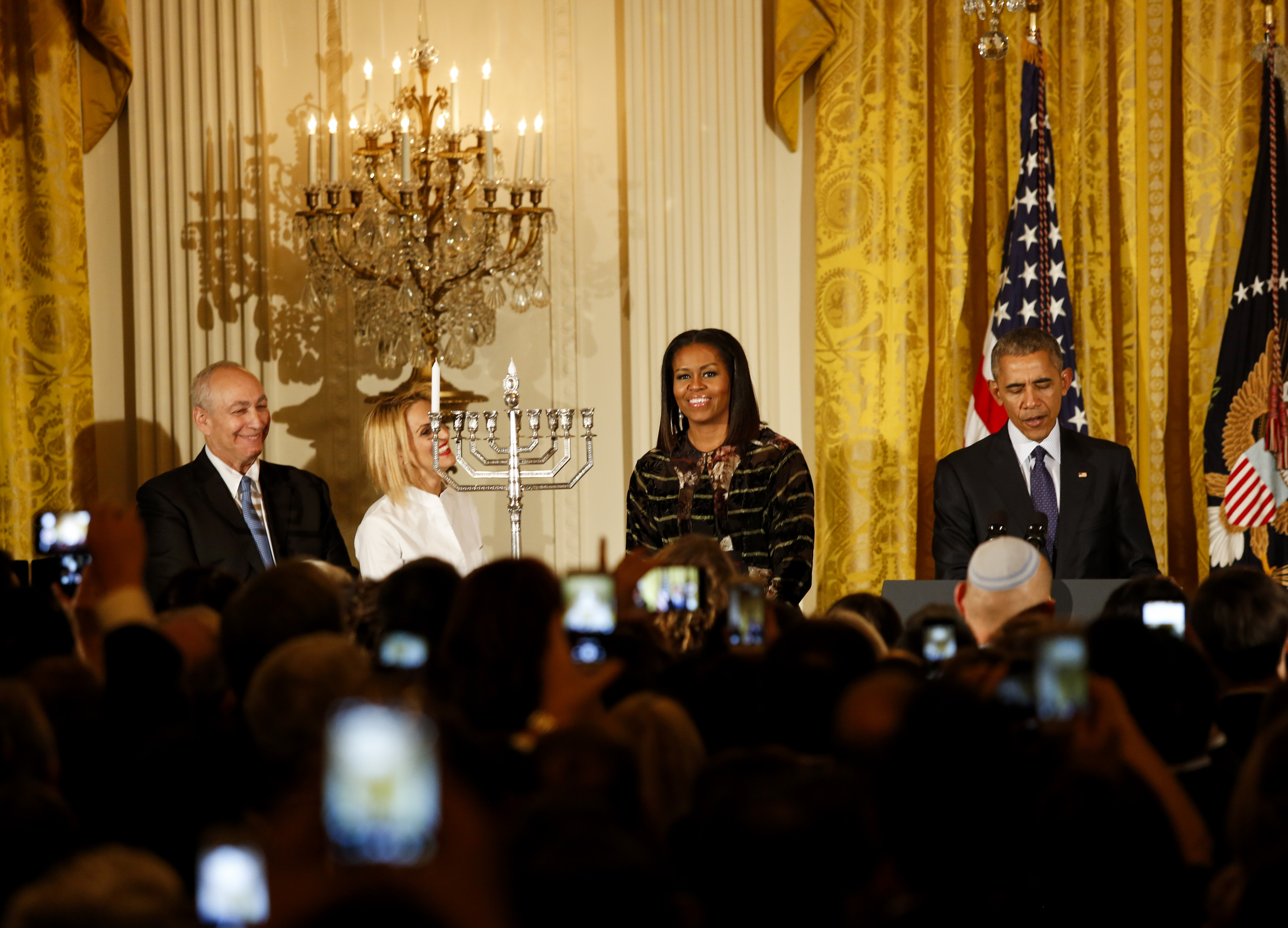 President Barack Obama, with wife Michelle, speaks at a Hanukkah reception with the son and granddaughter of the late Israeli President Shimon Peres — Chemi Peres, left, and Mika Almog — at the White House, Dec. 14, 2016. (Aude Guerrucci-pool/Getty Images)