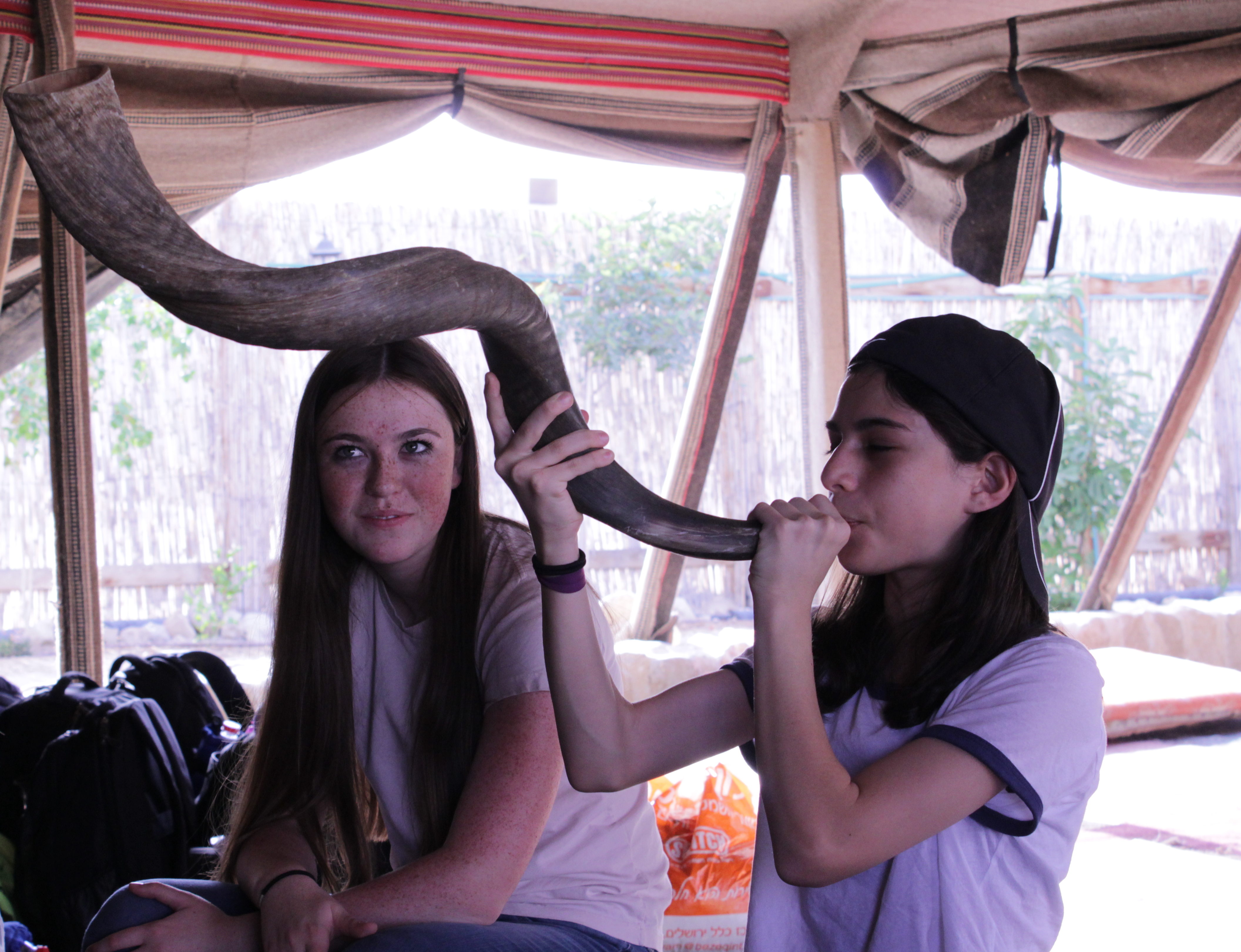 During a drumming circle in a Bedouin tent, THA students took turns blowing a shofar. Pictured, Ana Rosman (right) with Katherine Kanter )Jon Ben-Asher)
