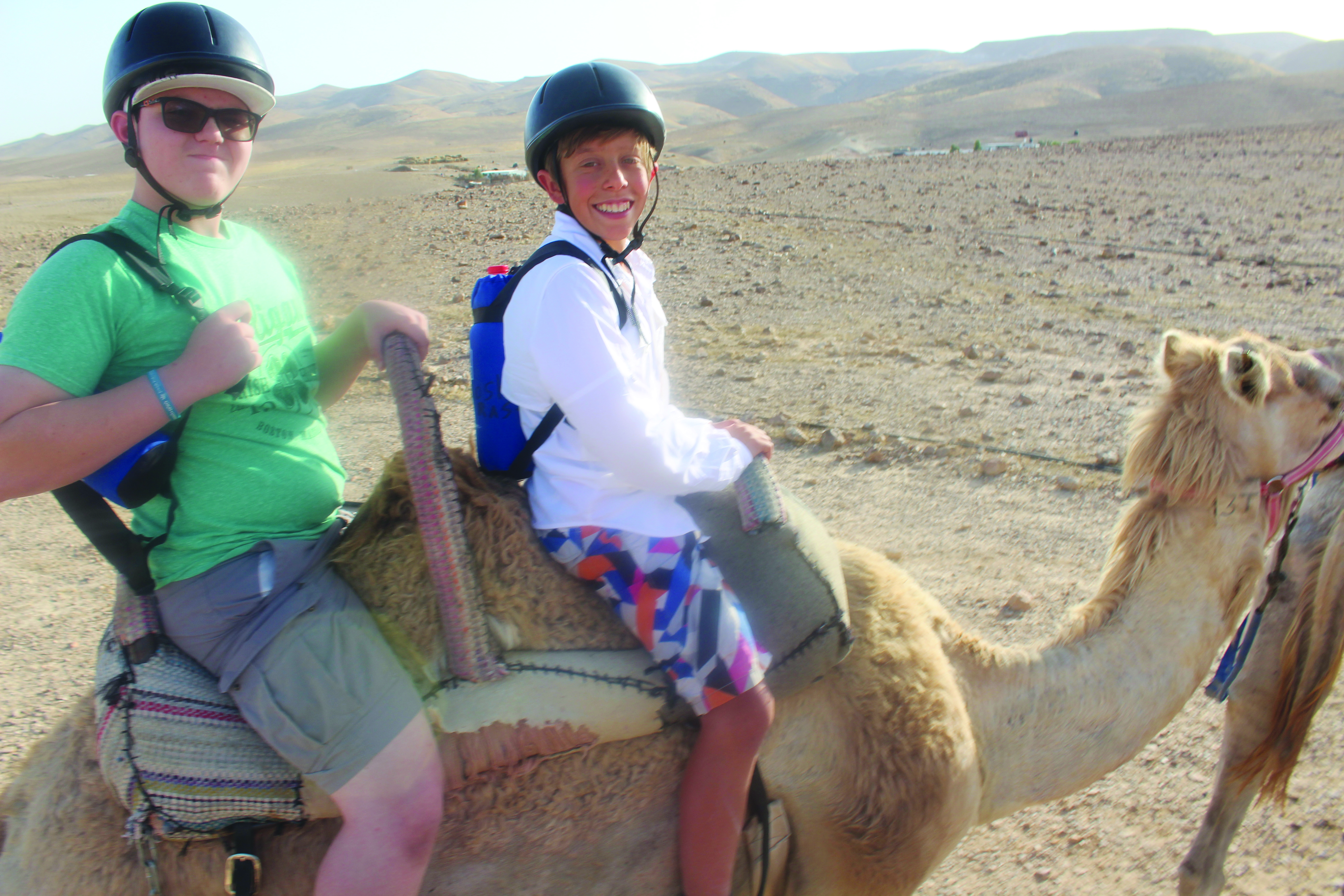 THA eighth graders Jayden Yalen (left) and Moshe Rast are ready for a camel ride in the Negev. (Jon Ben-Asher)