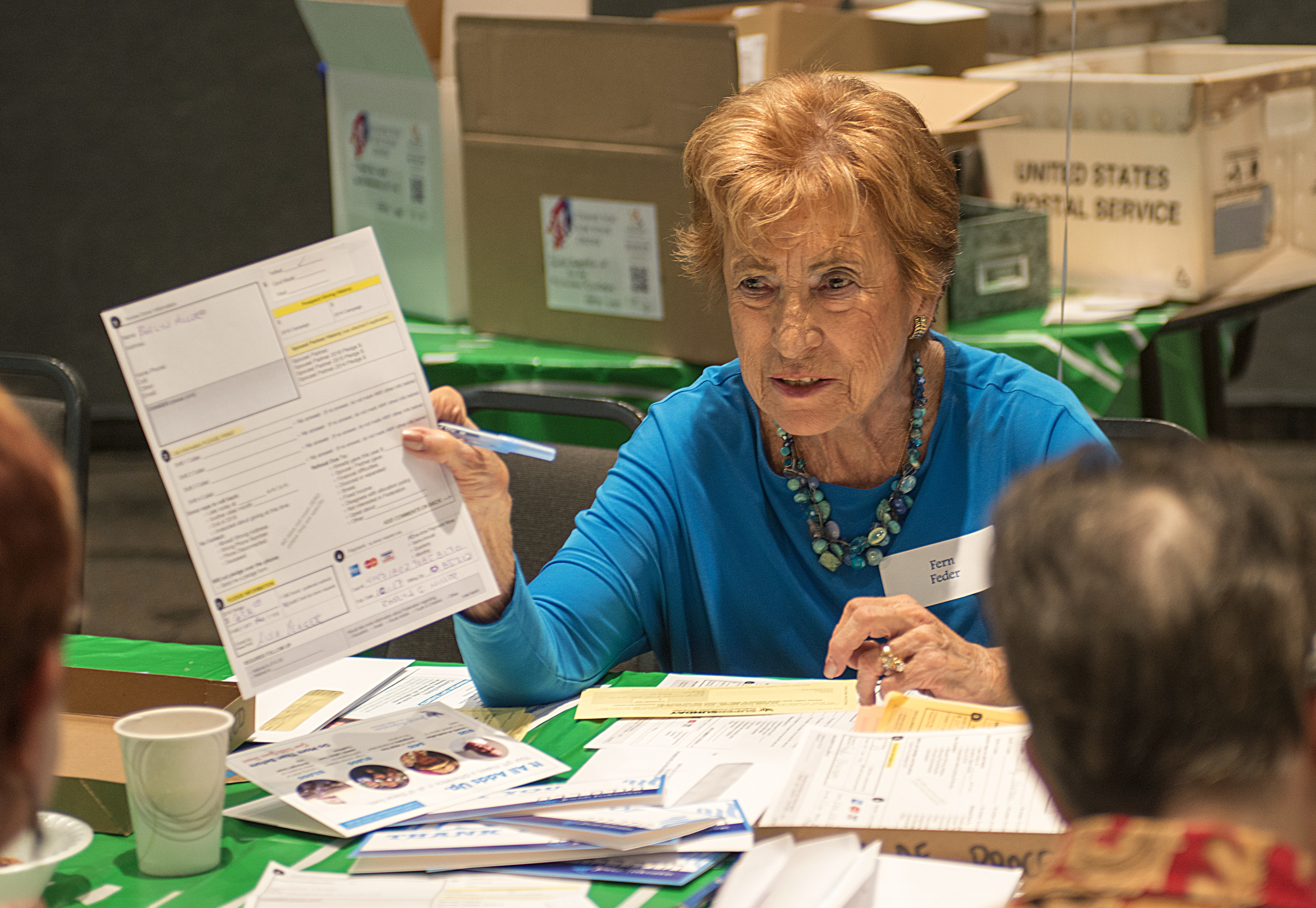 Fern Feder, a clerical volunteer, works with a community member’s donation form. (John Wu)