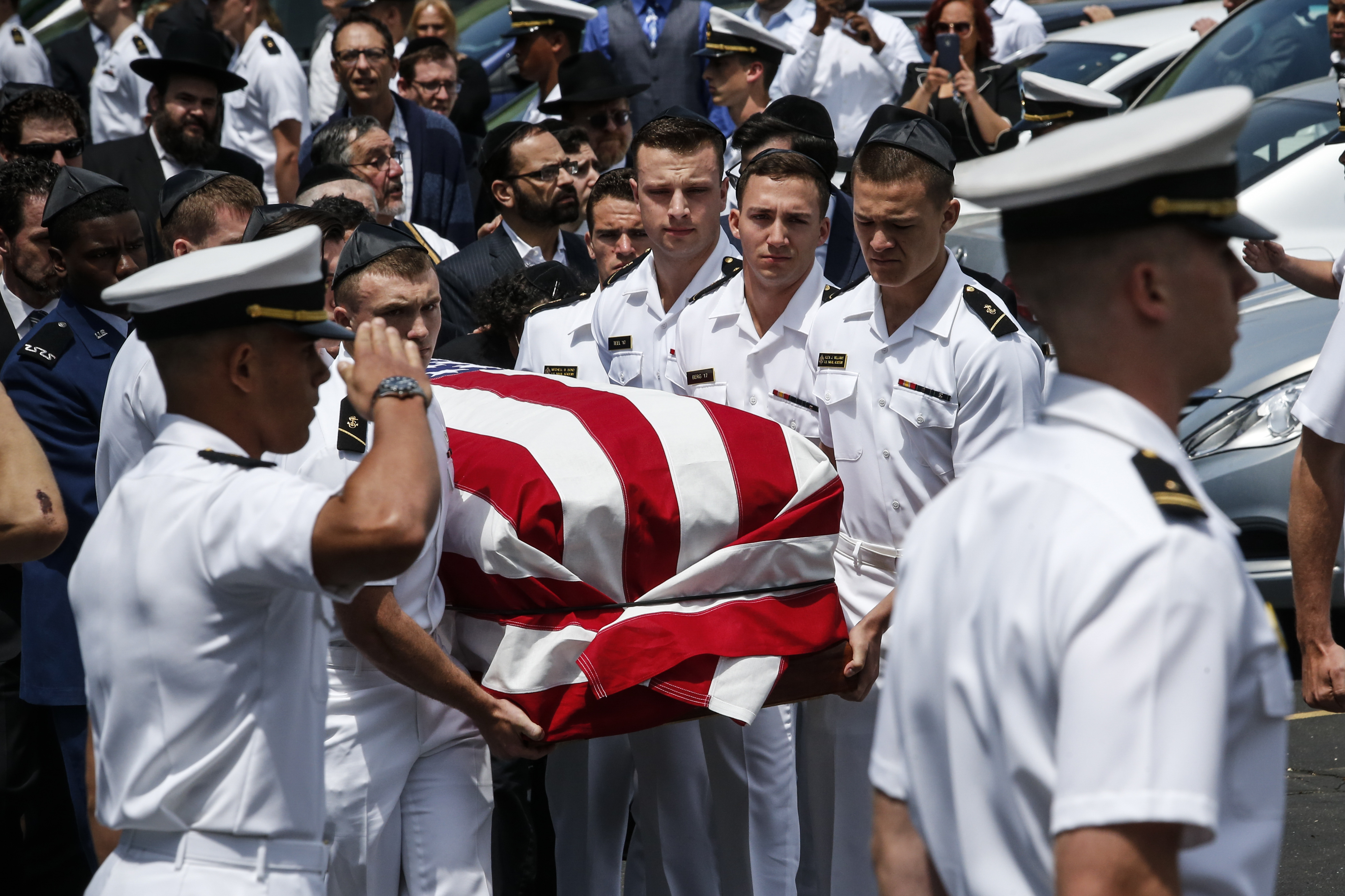 Midshipmen from the U.S Naval Academy carry the flag-draped casket of comrade Justin Zemser to a waiting car following his funeral in Hewlett, N.Y., May 15, 2015. (Kena Betancur/Getty Images)