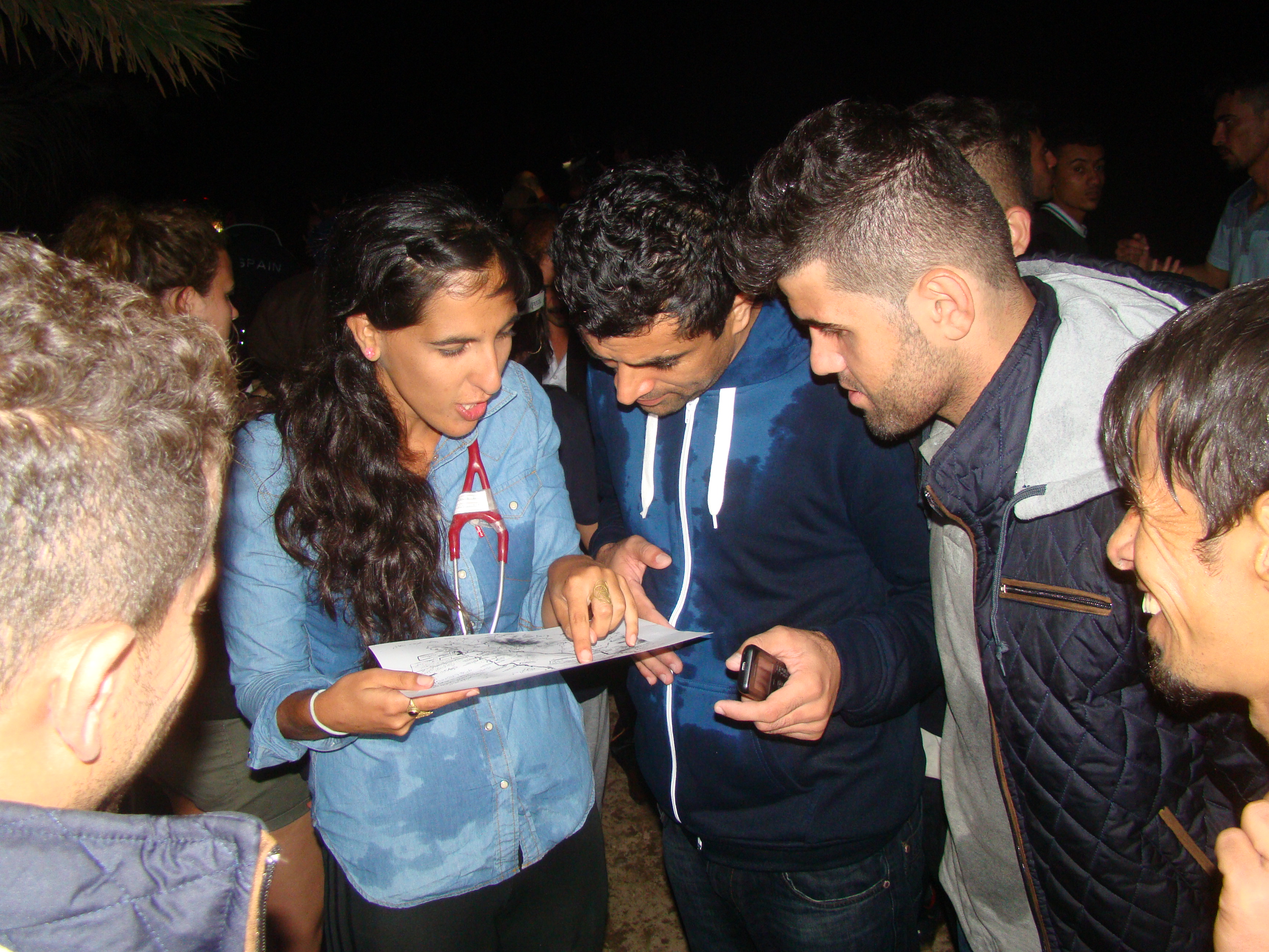 Dr. Tali Shaltiel explaining to a group of Afghans how to get to the refugee registration center some 40 miles away. (Gavin Rabinowitz)