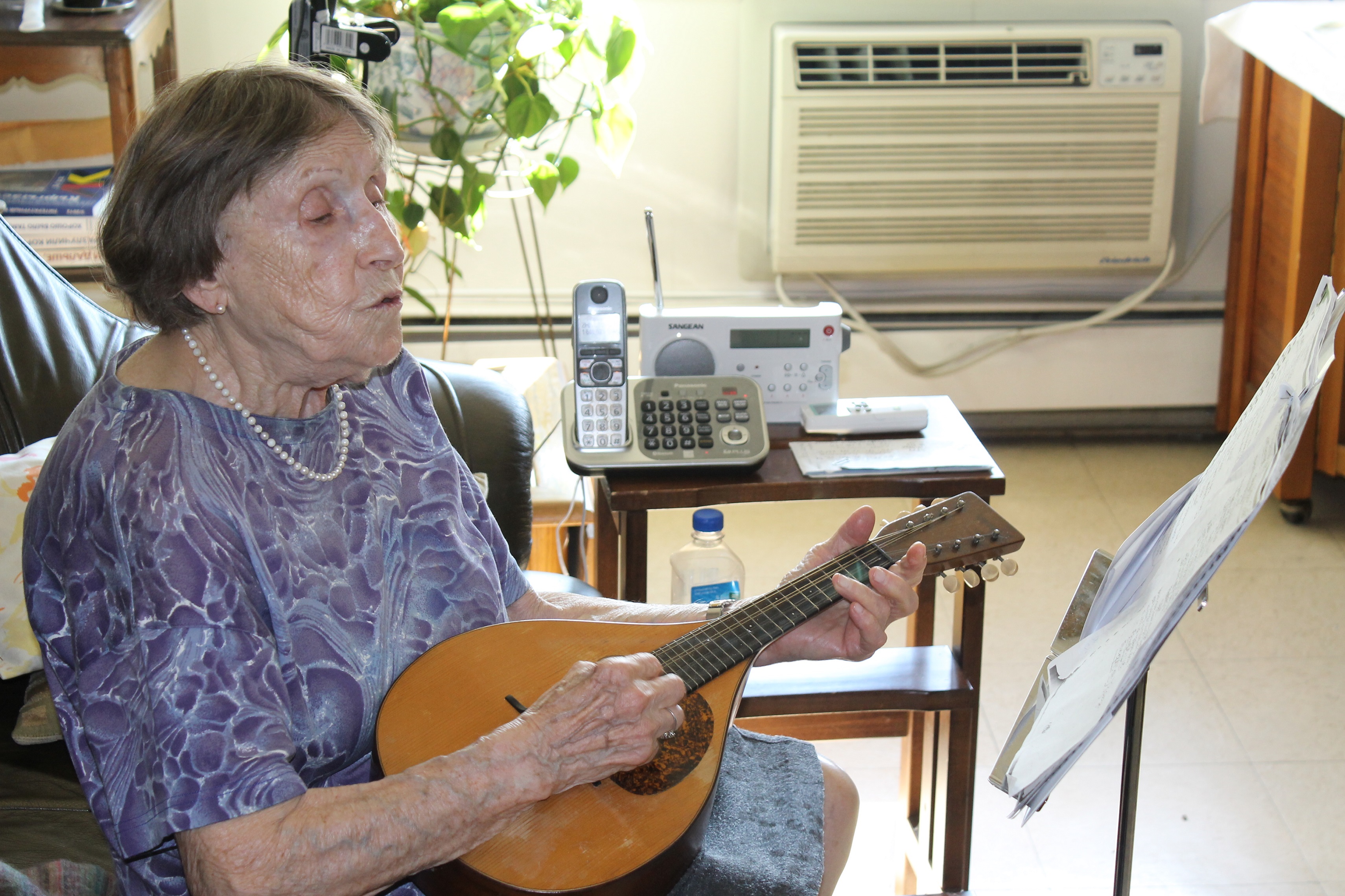 Emily Kessler strums the mandolin in her Upper West side apartment. (Raffi Wineburg/JTA)
