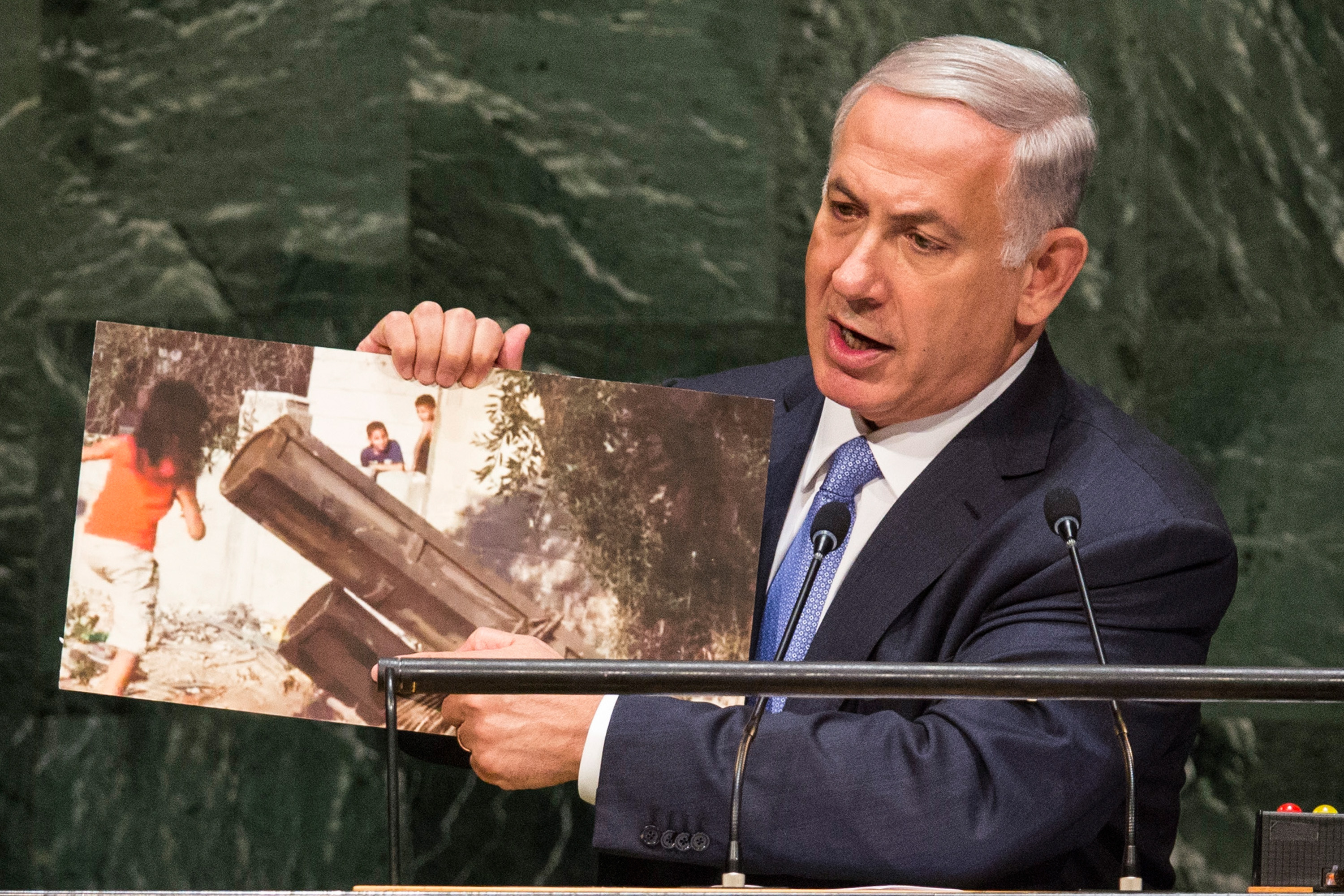 Israeli Prime Minister Benjamin Netanyahu during his address at the U.N. General Assembly shows a photo of a rocket launcher in a civilian area of Gaza with children nearby, Sept. 29, 2014. (Andrew Burton/Getty Images)