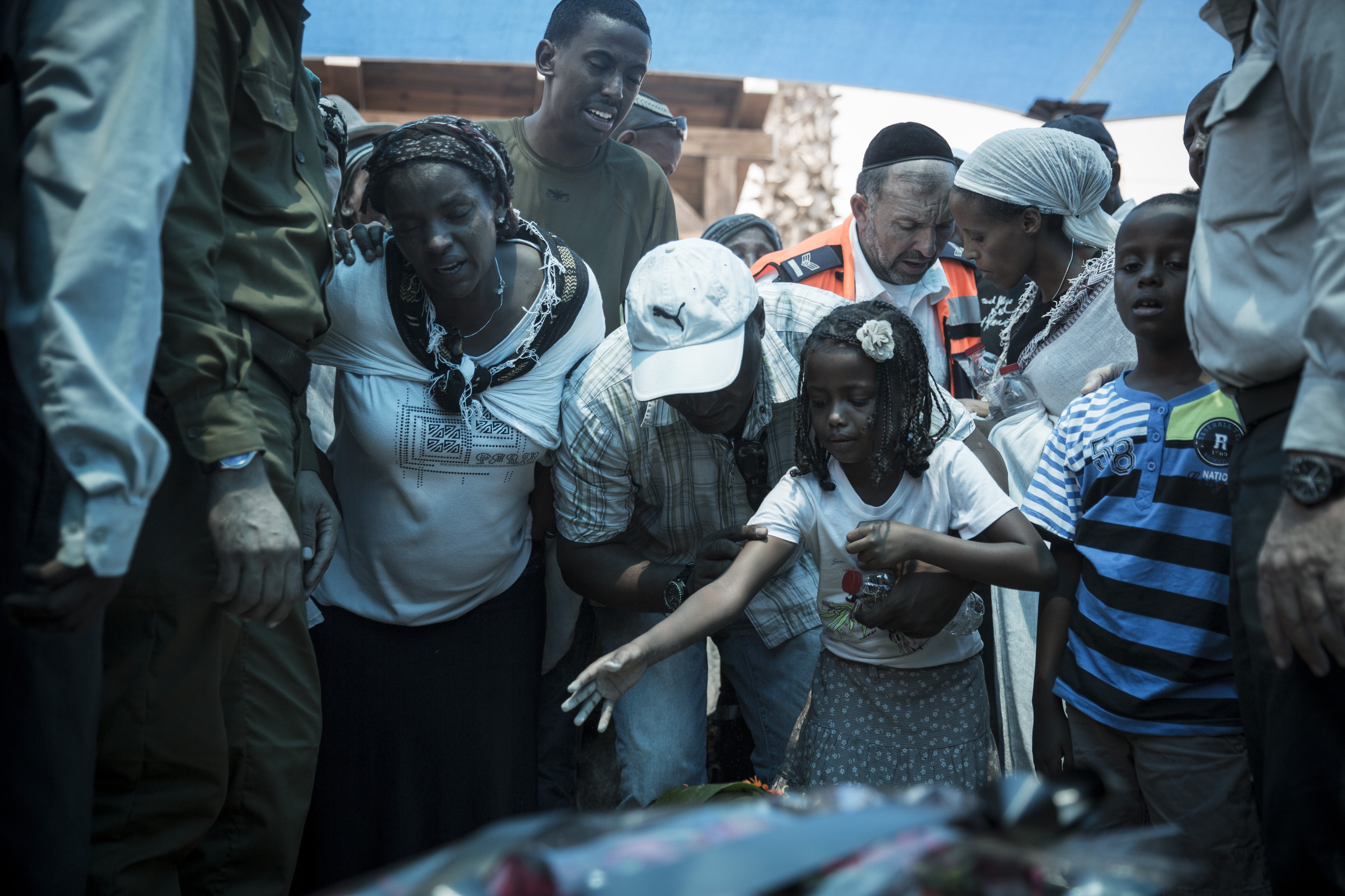 The wife and young daughter of Sergeant Major Bayhesain Kshaun cry at his gravesite during the funeral ceremony at the Netivot military cemetery, July 22, 2014. Kshaun, 39, was killed by an anti-tank missile fired at the force responding to a terrorist infiltration incident on July 21. (Hadas Parush/Flash90)