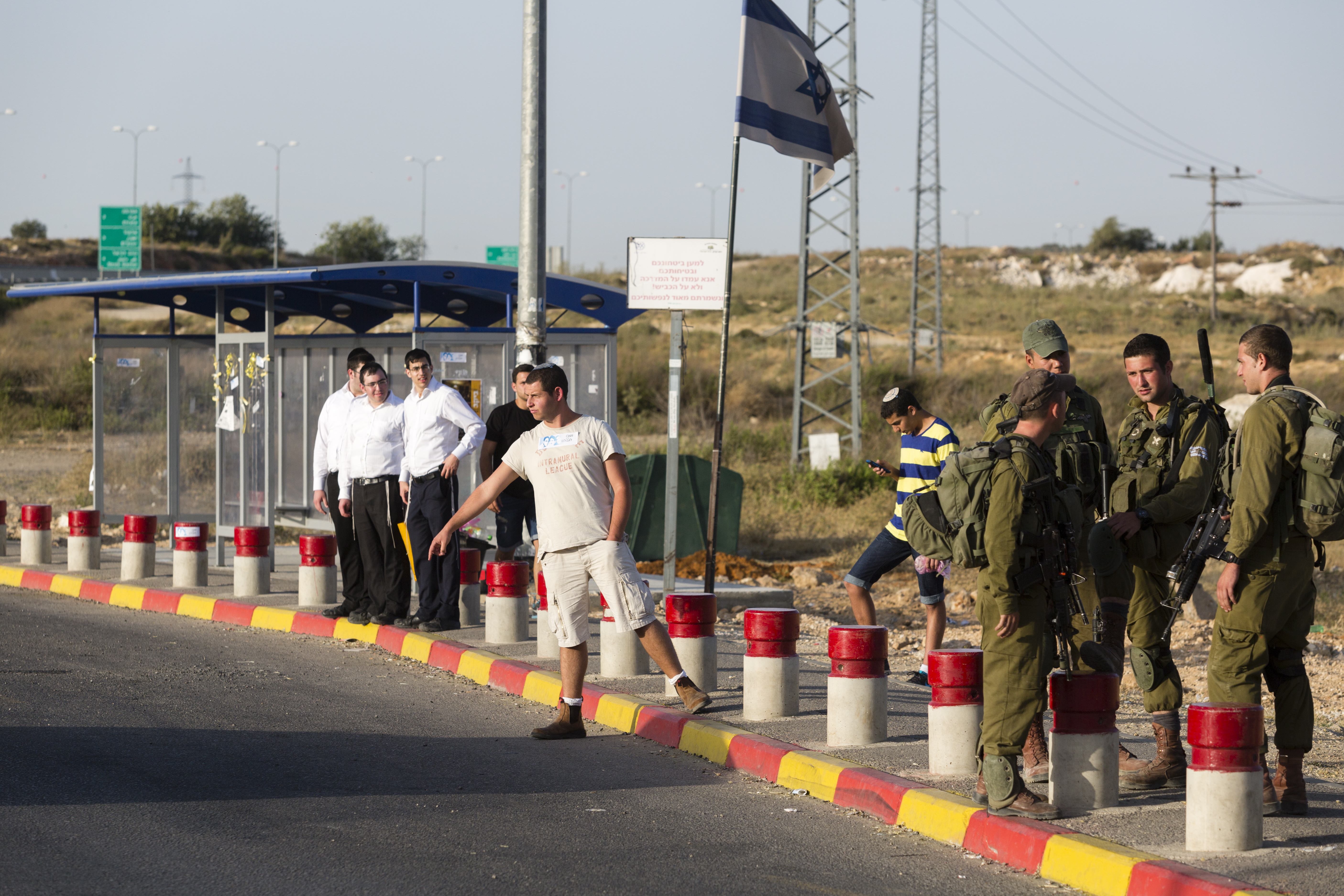 Israeli soldiers guard near where Jewish settlers hitchhike at the Gush Etzion junction in the West Bank, June 16, 2014/ (Flash 90)