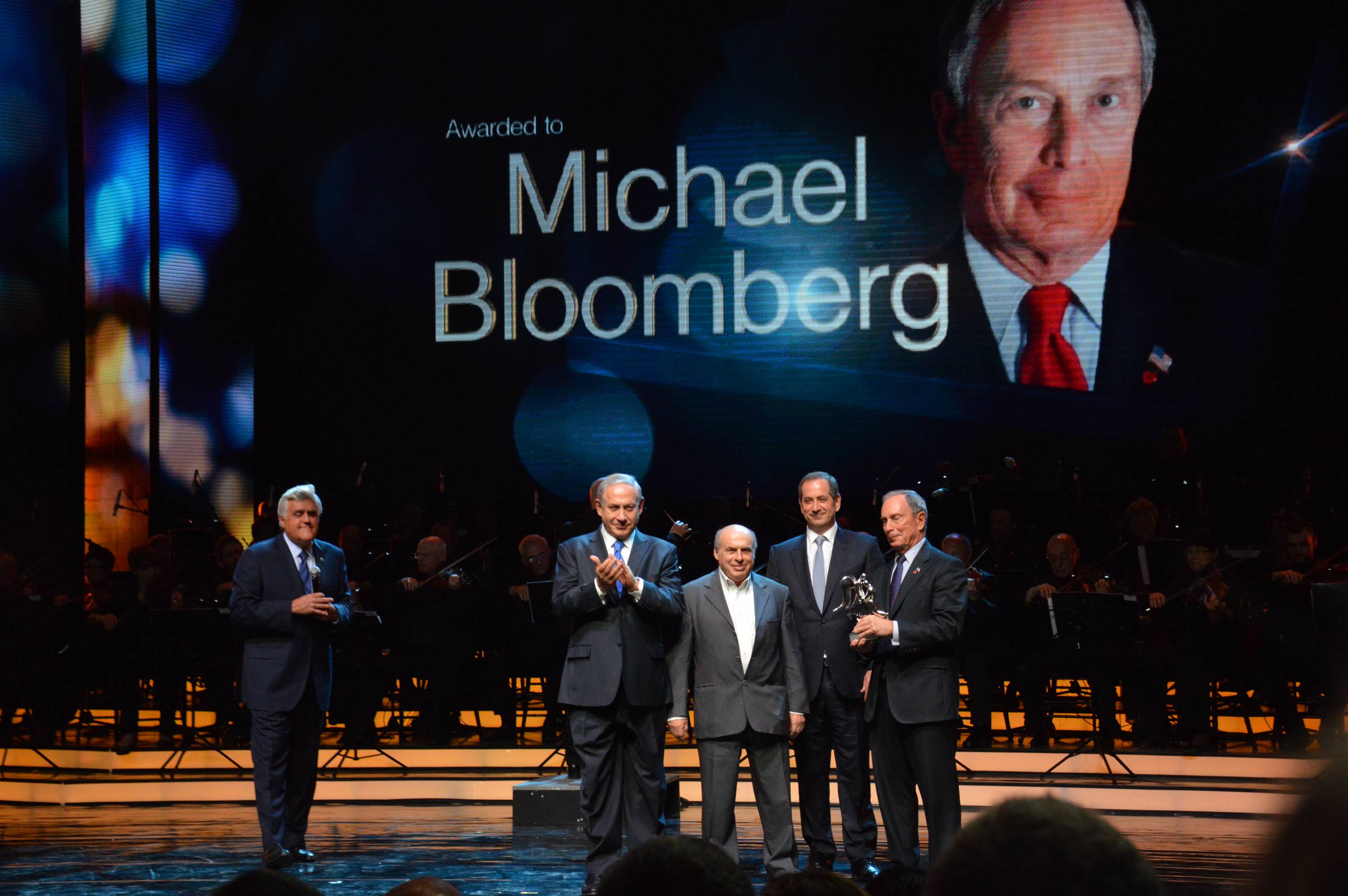 Former New York City Mayor Michael Bloomberg, at far right, receives the Genesis Prize on May 22, 2014 at the Jerusalem Theater, where he is joined onstage by, from left, ceremony emcee and former "Tonight Show" host Jay Leno; Israeli Prime Minister Benjamin Netanyahu; the chairman of the Jewish Agency, Natan Sharansky; and the chairman of the Genesis Prize, Stan Polovets. (Milner/Genesis)