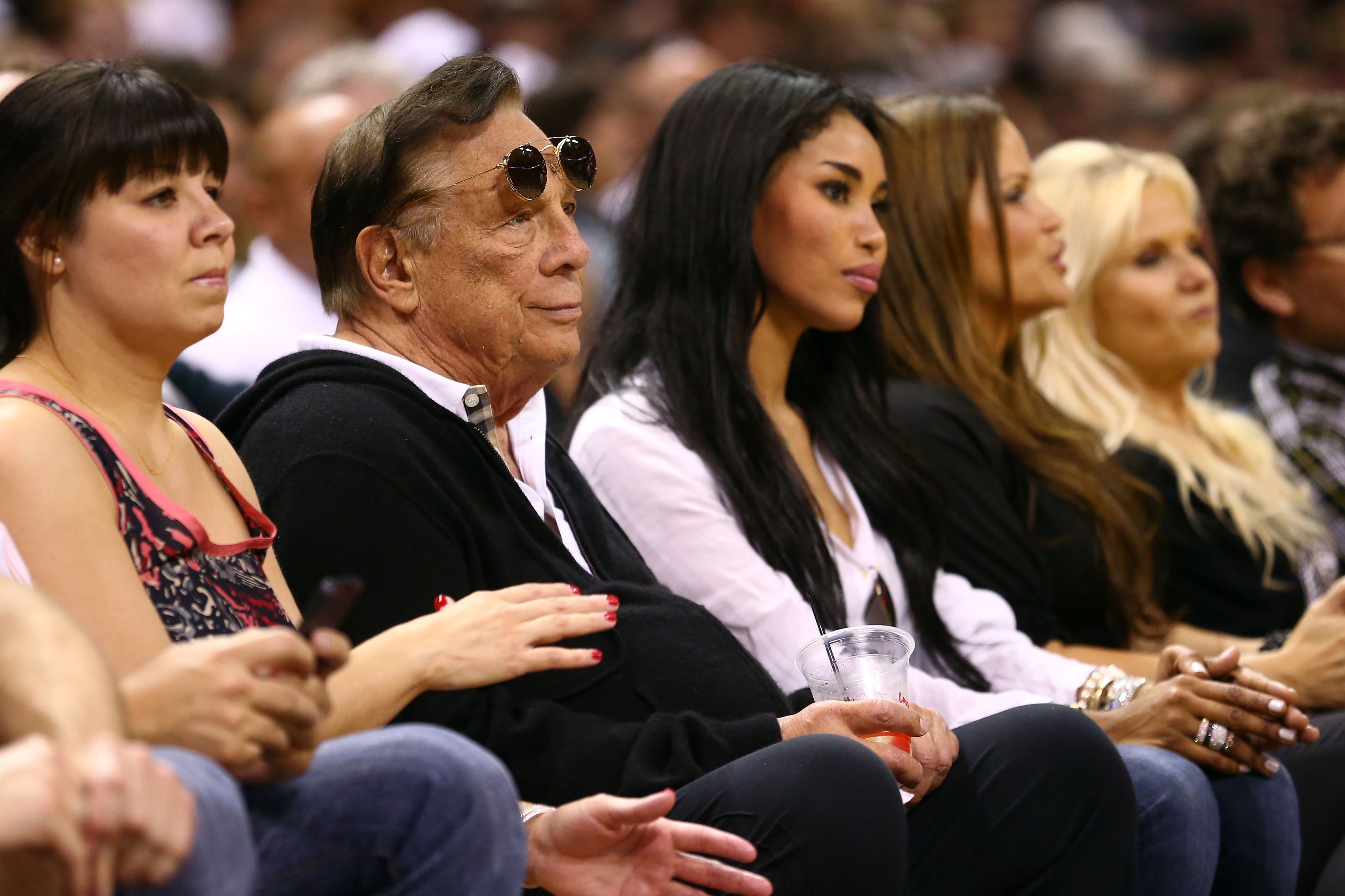 Los Angeles Clippers owner Donald Sterling is pictured with V. Stiviano to his left at a 2013 basketball game. (Ronald Martinez/Getty Images)