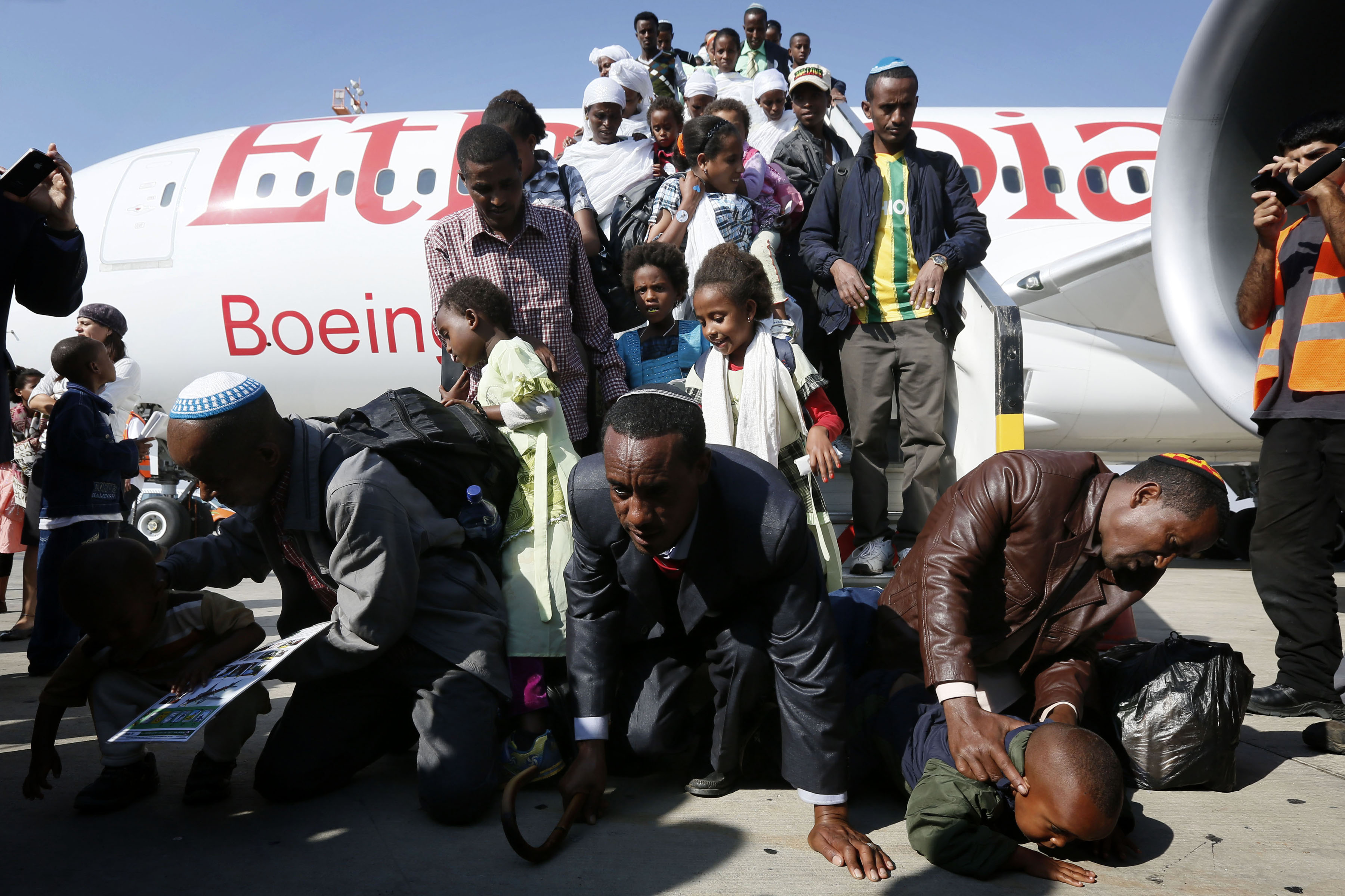 Ethiopian Jews kiss the ground upon arrival at Ben Gurion Airport as part of Operation Wings of Dove, which ended the Ethiopian immigration to Israel, Aug. 28, 2013. (Miriam Alster/Flash 90/JTA)