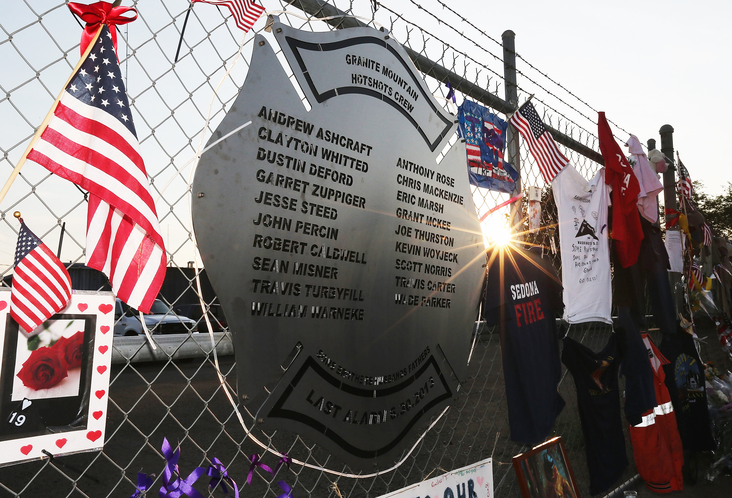 A plaque engraved with names of the 19 fallen firefighters from the Granite Mountain Interagency Hotshot Crew is mounted on a fence outside Station 7, their home base in Prescott, Ariz., July 3, 2013. (Photo by Christian Petersen/Getty Images)