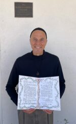 A mddle aged man wearing a kippah holds his certificate of conversion to Judaism.